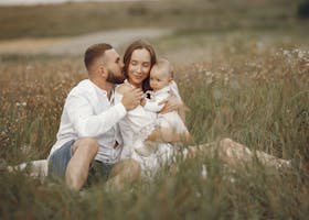 Happy family enjoying quality time in a serene meadow setting.